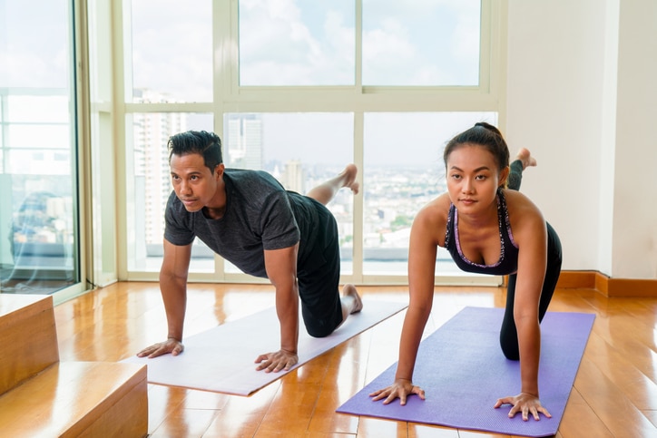 Young adult couple doing yoga at home. Bangkok, Thailand. April 2017