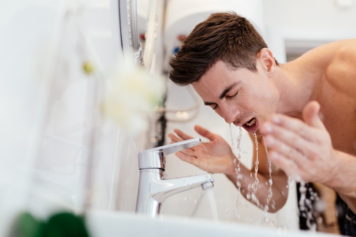 Man washing face in morning and practicing hygiene