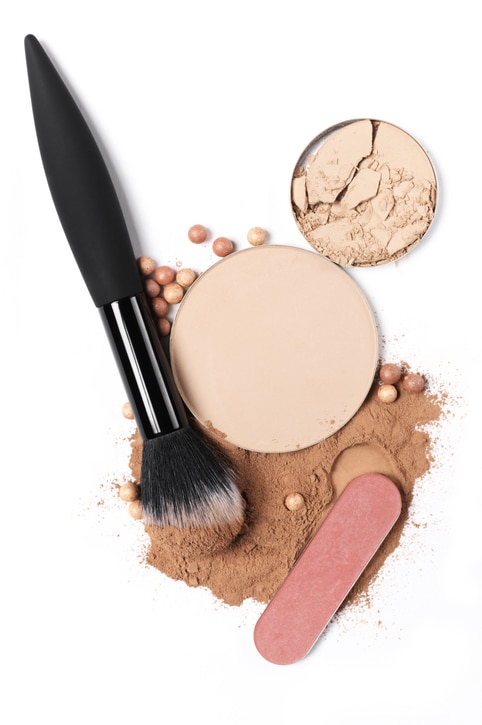 Cosmetic set of compact and loose face powder, bronzed pearls, blush and makeup brush isolated on white background. Top view point, flat lay.