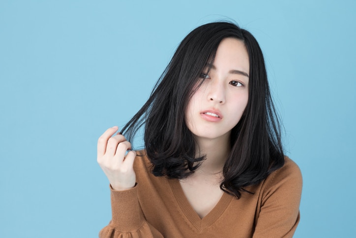 portrait of attractive asian woman isolated on blue background