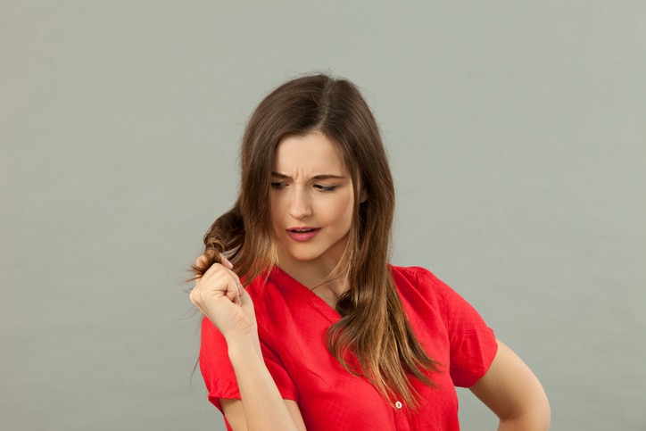 portrait in studio close-up of an attractive 20 year old girl in a red shirt on a gray background