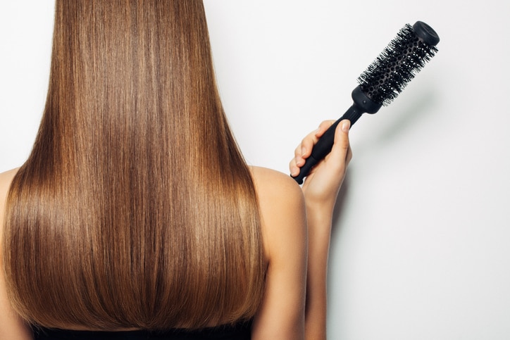 Woman standing with her back and demonstrates luxurious hairstyle