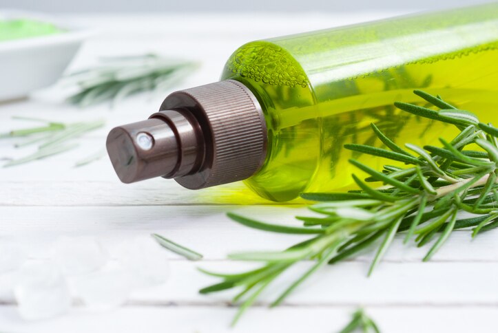 cosmetic creams and rosemary on white wooden table