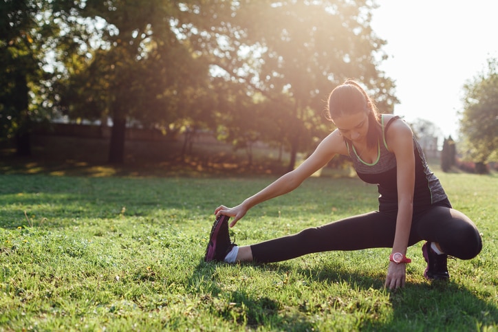 Young woman doing some warm-up exercises before running.