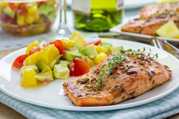 Spice grilled salmon with mango-avocado salsa on a white plate