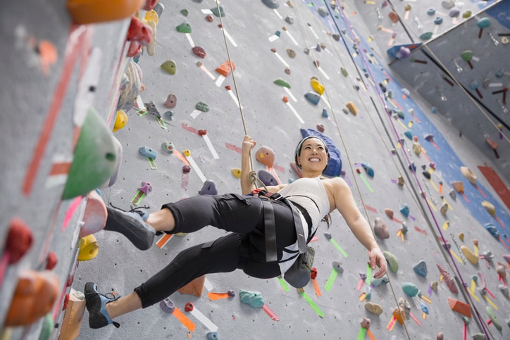 Smiling woman climbing indoor rock wall, MBTI 16 Personalities – ISTP: The Crafter