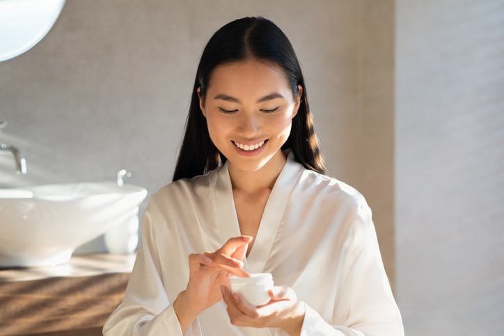 young asian lady in white bathrobe holding jar with beauty product, MBTI 16 Personalities – The best skincare gift for ISTP